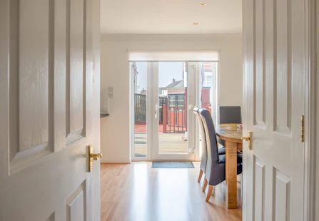 Modern Scottish Kitchen Dinning Room with Oak table and Chairs in clean White Painted Coloirs looking onto the Patio doors.