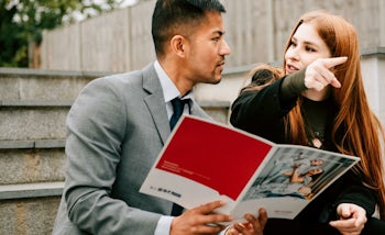 Estate agent showing a brochure to a potential franchisee in East Midlands
