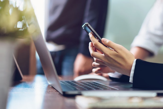 Business woman holding smartphone, using cell phone on office. Technology for communication concept.