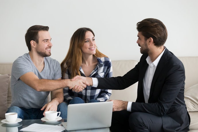 Happy family couple renters tenants handshaking realtor landlord at meeting