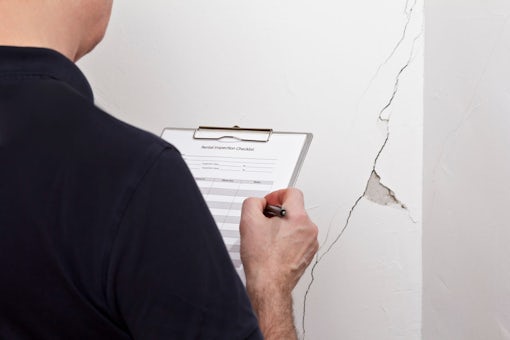 man inspection wall crack rip