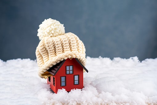 cold snowy weather with model of a house wearing a knitted cap