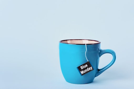 Tea bag with Blue Monday text in blue mug on blue background.