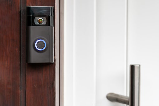 A modern surveillance camera is installed on a front door.A mode