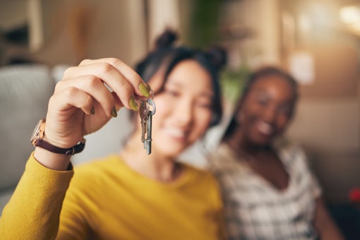 Hand, keys and new home or people moving in together for real estate investment. Rent, mortgage and loan closeup of women friends celebrate at apartment, property or house with a partner for freedom