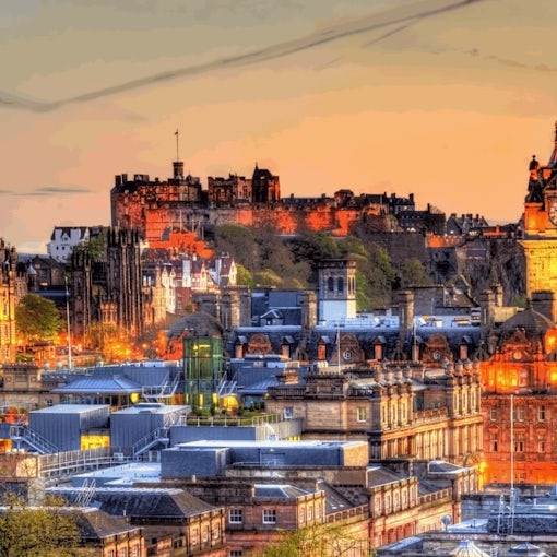 iew of Edinburgh city skyline at sunset with Edinburgh Castle.