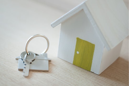 House shaped decoration with a yellow door, and a set of keys