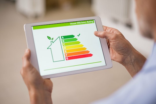 Man holds a tabled that shows home energy efficient classes.