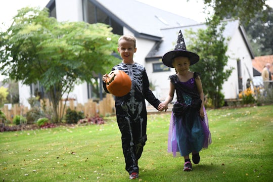 Two kids dressed for halloween in front of a house Two kids dressed for halloween in front of a house Two kids dressed for Halloween in front of a house