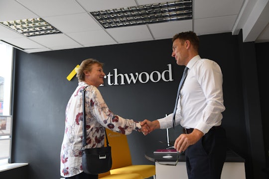Estate agent and home buyer shaking hands