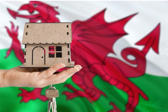 House and keys in front of the Welsh flag.