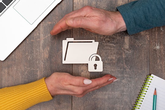 Secured folder icon between man and woman hands.