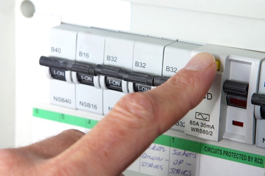 Finger on a RCD (Residual Current Device) on a UK domestic electrical consumer unit or fuse box