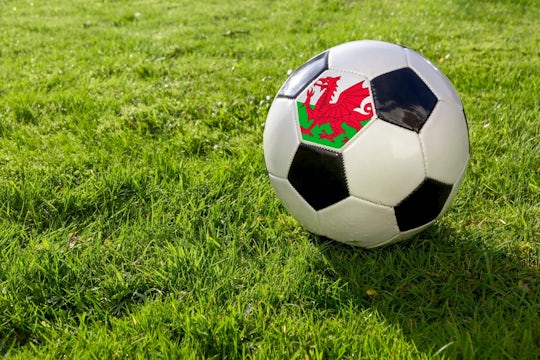 Football with Welsh flag patch on a football pitch,